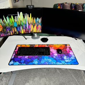 colorful neoprene desk mat on a white desk with a keyboard and mouse