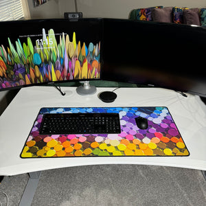 colorful neoprene desk mat on a white desk with a keyboard and mouse