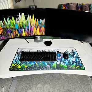 colorful neoprene desk mat on a white desk with a keyboard and mouse