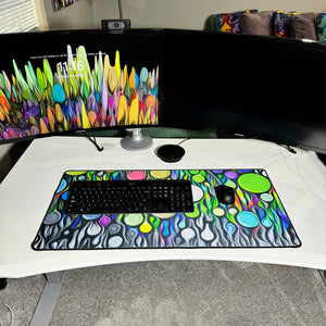 colorful neoprene desk mat on a white desk with a keyboard and mouse