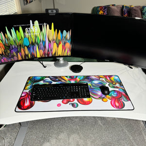 colorful neoprene desk mat on a white desk with a keyboard and mouse